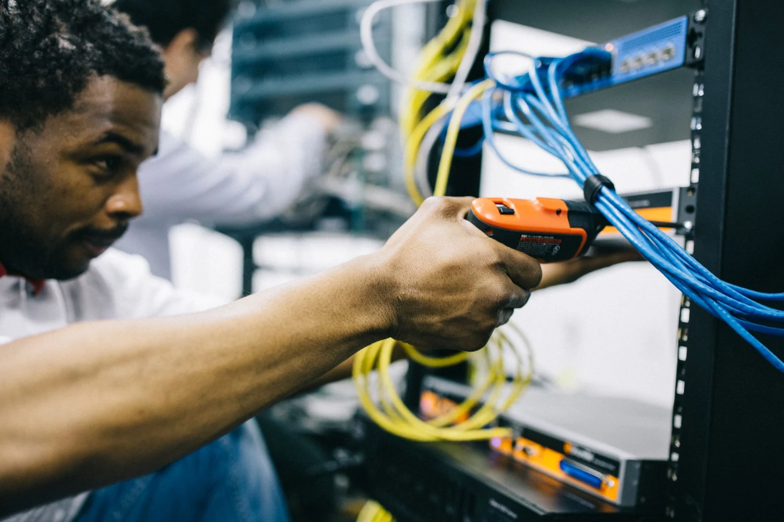 A technician fitting network hardware into a rack