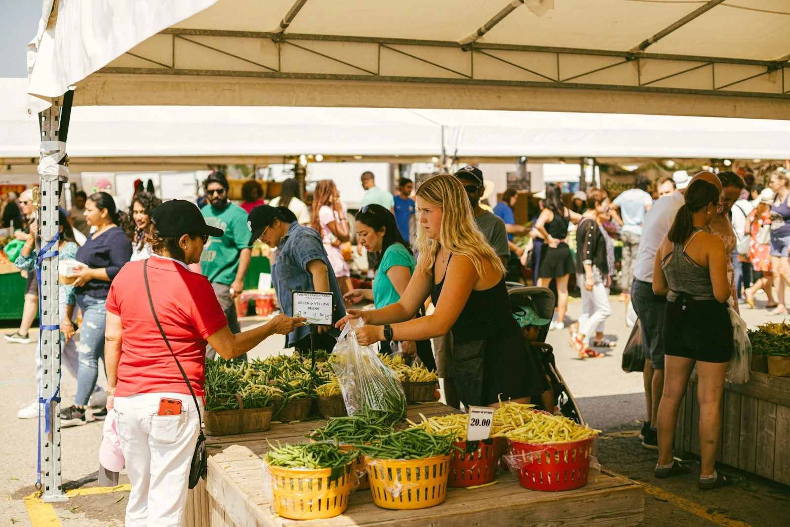 A busy outdoor market, people crowding round the stalls