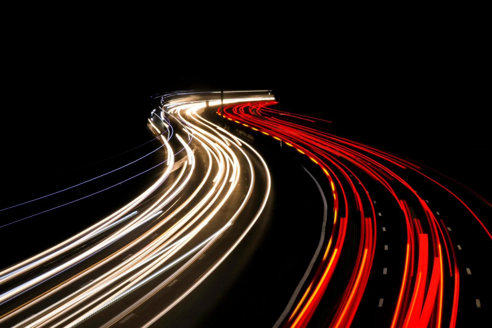 Light trails of traffic sweeping along a highway at night